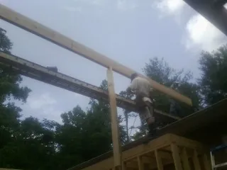 Carpenter setting a ridge beam over a new addition frame — Ice Dam Removal by Roofing Brothers in Chapman Ranch