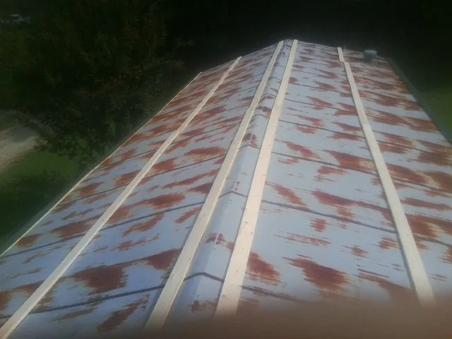 Rusted metal roof panels with new wood purlins before replacement — Storm Damage Roof Repair in Chapman Ranch by Roofing Brothers
