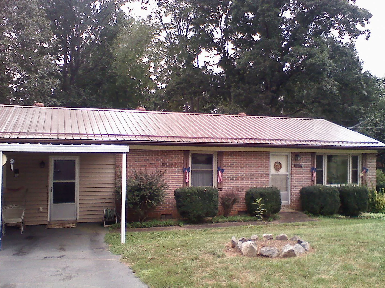Bronze metal roof and carport on a brick ranch home — Roof Repair work by our crew in Chapman Ranch
